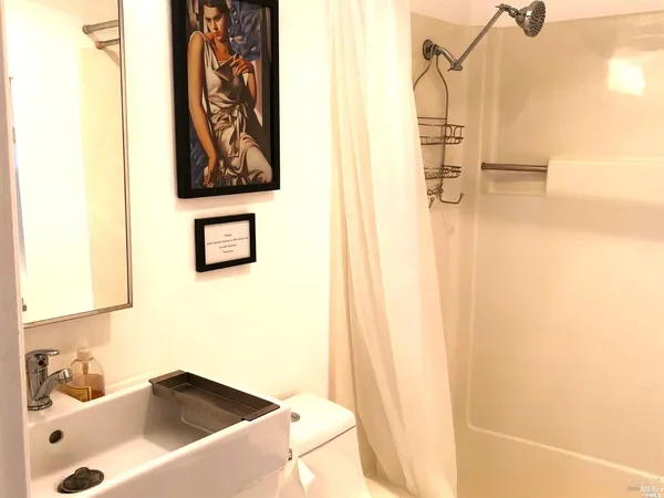 a view of a white house with a large tree