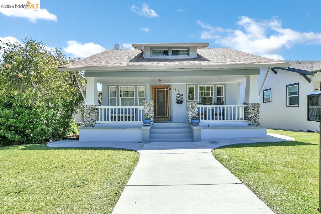 325 South 2nd Street Rio Vista, CA 94571 - Photo 6 of 33 Craftsman-style facade with a covered front porch featuring stone-clad pillars, white railing, and a wood-paneled entry door