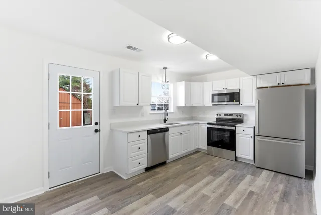 a kitchen with granite countertop a refrigerator stove top oven and sink