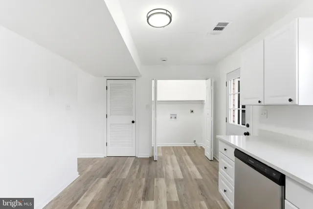 a view of a kitchen with wooden floor and electronic appliances