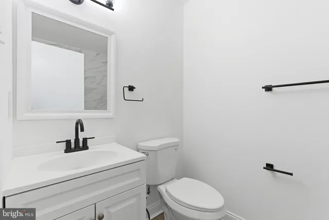 a bathroom with a toilet a sink and mirror