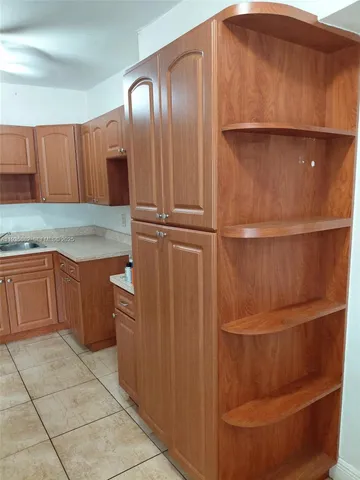 a kitchen with a cabinets and a refrigerator