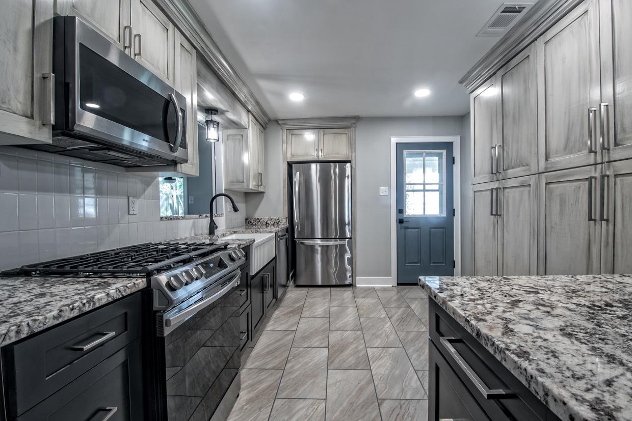 4582 Boyce Road Memphis, TN 38117 - Photo 3 of 22 a kitchen with stainless steel appliances granite countertop a stove refrigerator and microwave
