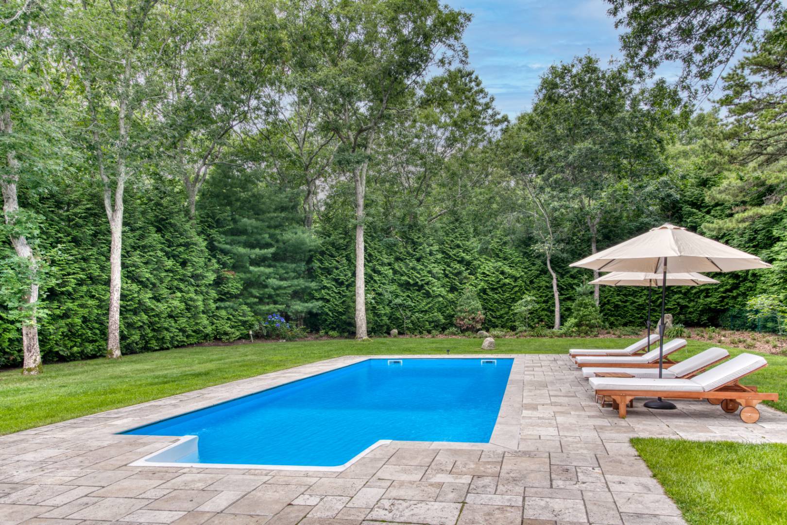 3 Short Lane East Hampton, NY 11937 - Photo 12 of 13 a view of swimming pool with lawn chair under an umbrella