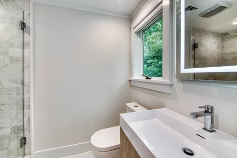 a bathroom with a sink a toilet and a window
