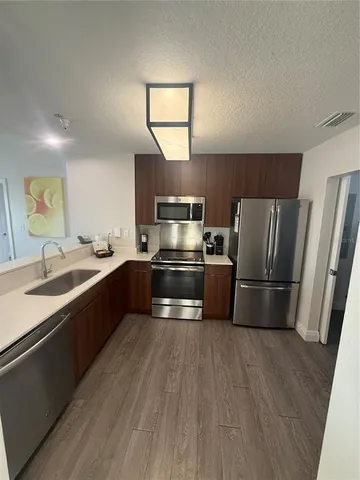 a kitchen with granite countertop a refrigerator and a sink