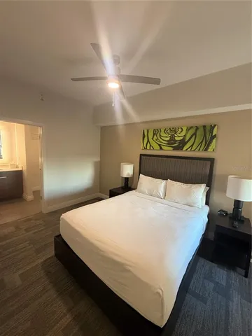 a large bed sitting in a bedroom next to a lamp