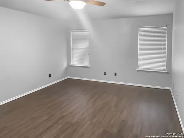 an empty room with wooden floor and window