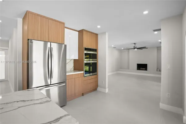 an empty room with windows and ceiling fan