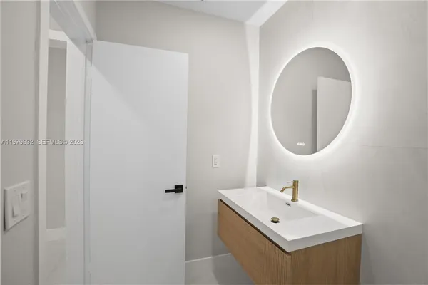 a view of a livingroom with a chandelier fan and windows