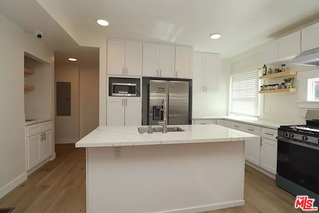 a kitchen with kitchen island stainless steel appliances a sink stove and refrigerator