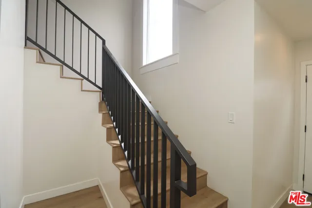 a view of staircase with wooden floor and white walls
