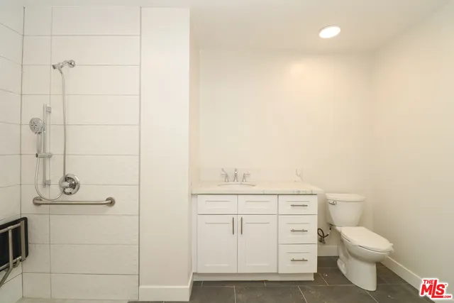a bathroom with a granite countertop toilet and sink