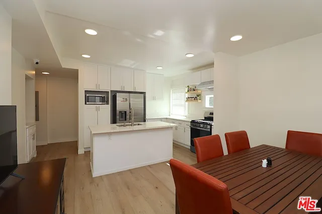 a kitchen with stainless steel appliances granite countertop a refrigerator and a stove top oven