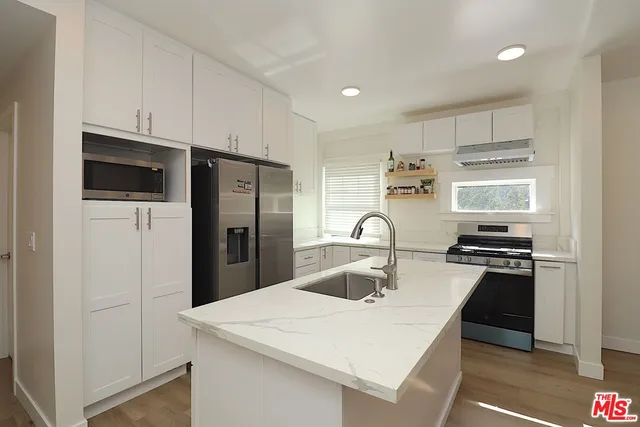 a kitchen with stainless steel appliances a stove refrigerator sink and microwave