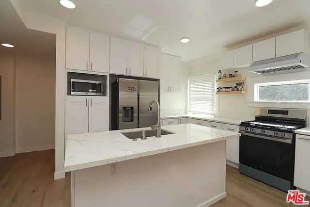 a kitchen with kitchen island a sink stove and refrigerator