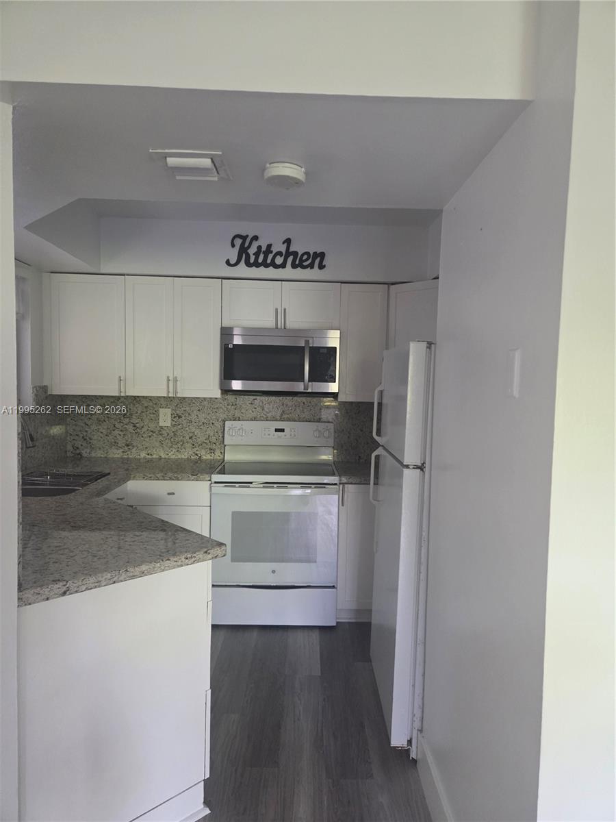 8365 Southwest 152nd Avenue, Unit 3 Miami, FL 33193 - Photo 11 of 25 a kitchen with stainless steel appliances granite countertop a refrigerator and a stove top oven
