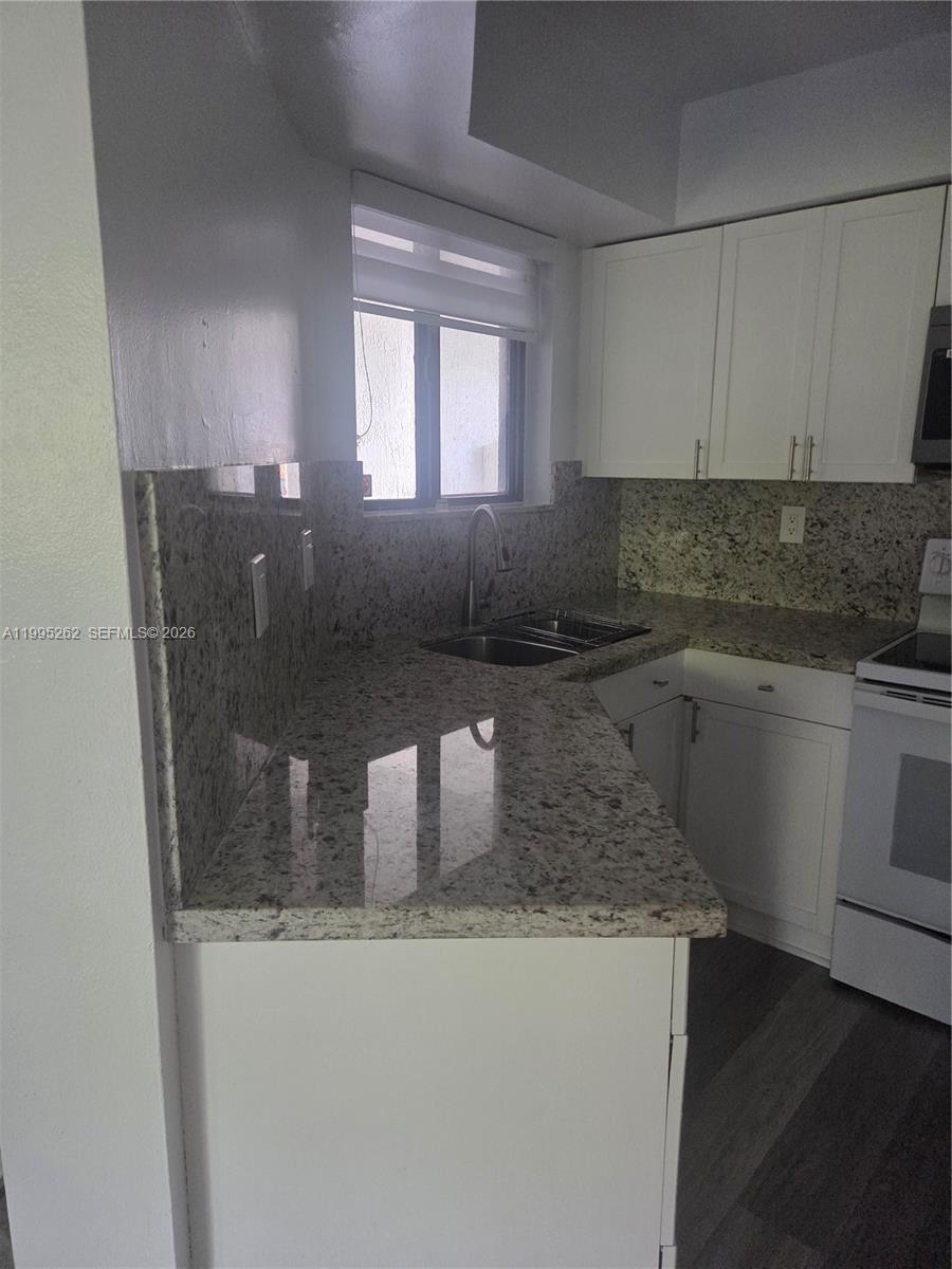8365 Southwest 152nd Avenue, Unit 3 Miami, FL 33193 - Photo 14 of 25 a kitchen with a sink a window and cabinets
