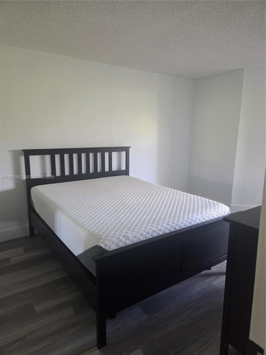 8365 Southwest 152nd Avenue, Unit 3 Miami, FL 33193 - Photo 19 of 25 a large bed sitting in a bedroom next to a lamp