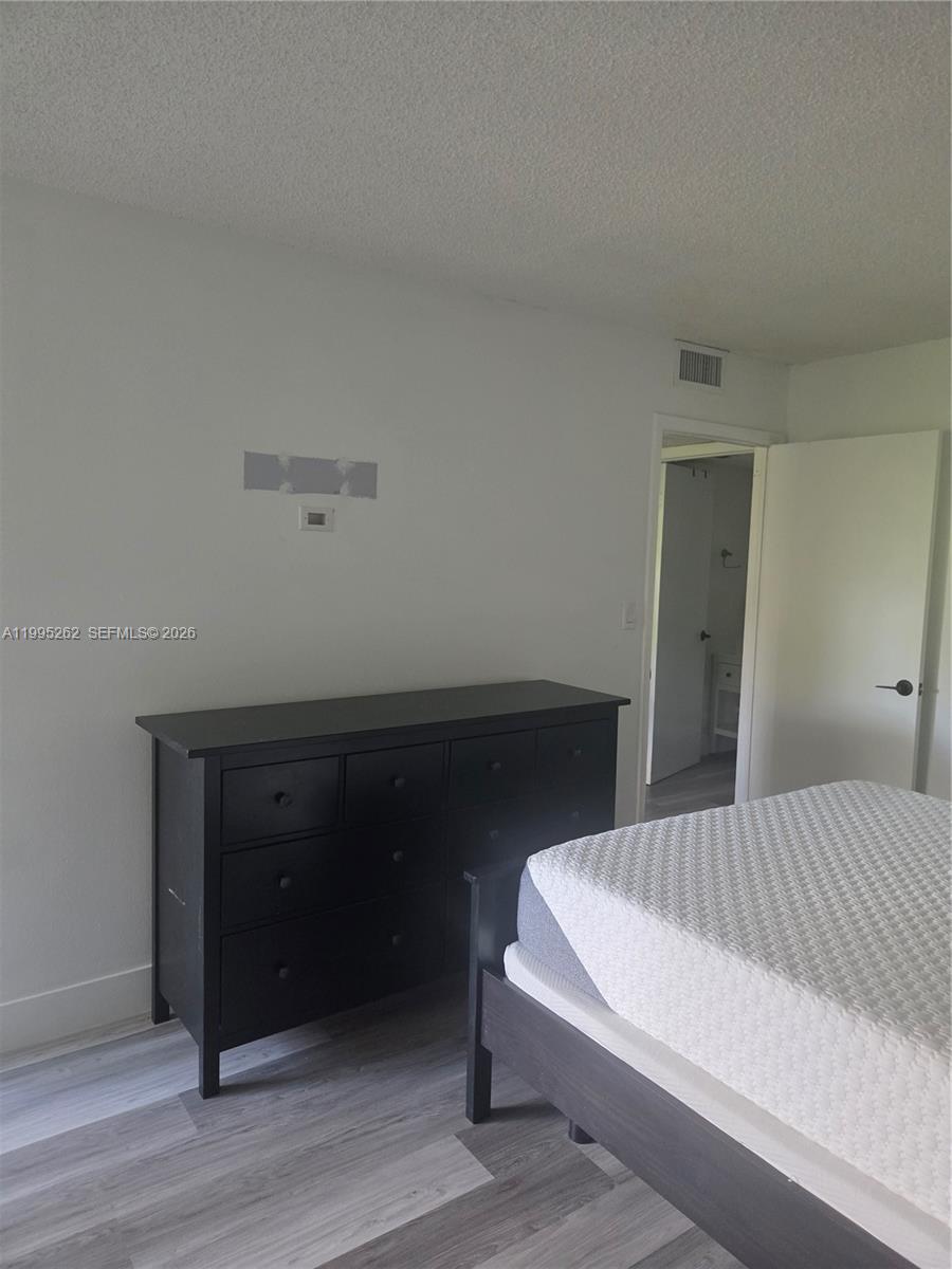 8365 Southwest 152nd Avenue, Unit 3 Miami, FL 33193 - Photo 21 of 25 a bedroom with a bed and a table