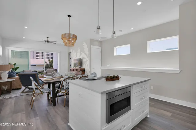 a kitchen with a stove a counter space dining table and chairs