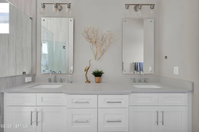 a bathroom with double vanity sinks a vanity and a mirror