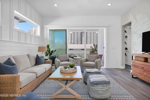 a living room with furniture a flat screen tv and a window