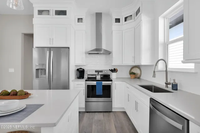 a kitchen with stainless steel appliances a sink dishwasher stove and refrigerator