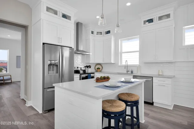a kitchen with refrigerator a sink and chairs