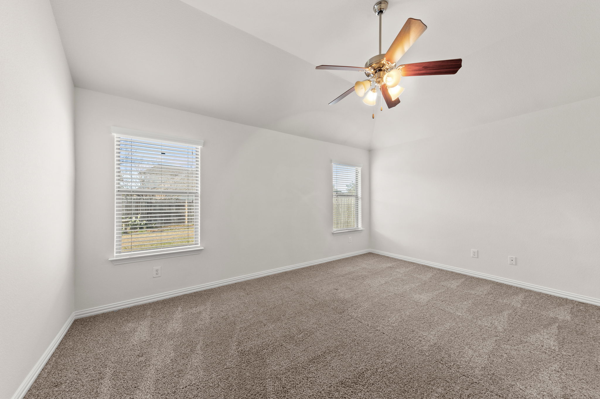 411 Tascate Street Georgetown, TX 78628 - Photo 20 of 41 A spacious, naturally illuminated room features soft carpeting and a classic ceiling fan for ultimate comfort.