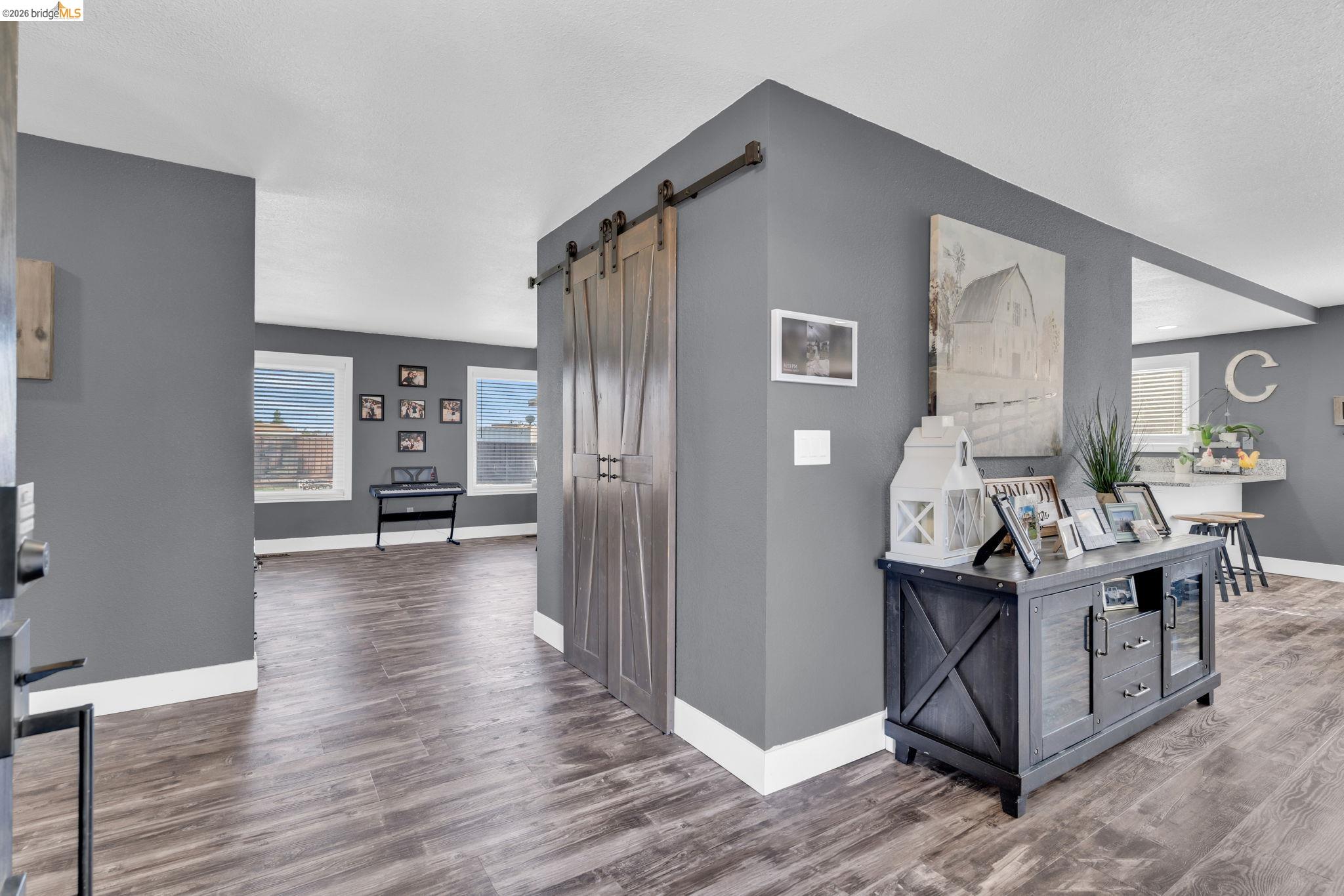 59 Old Stagecoach Road Brentwood, CA 94513 - Photo 12 of 70 Interior featuring wood-finish flooring, a sliding barn door, and a dedicated entry space with deep gray walls