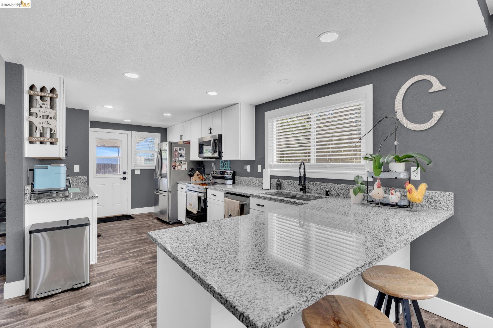 59 Old Stagecoach Road Brentwood, CA 94513 - Photo 19 of 70 Modern kitchen featuring wood-finish flooring, white cabinetry, recessed lighting, and granite countertops
