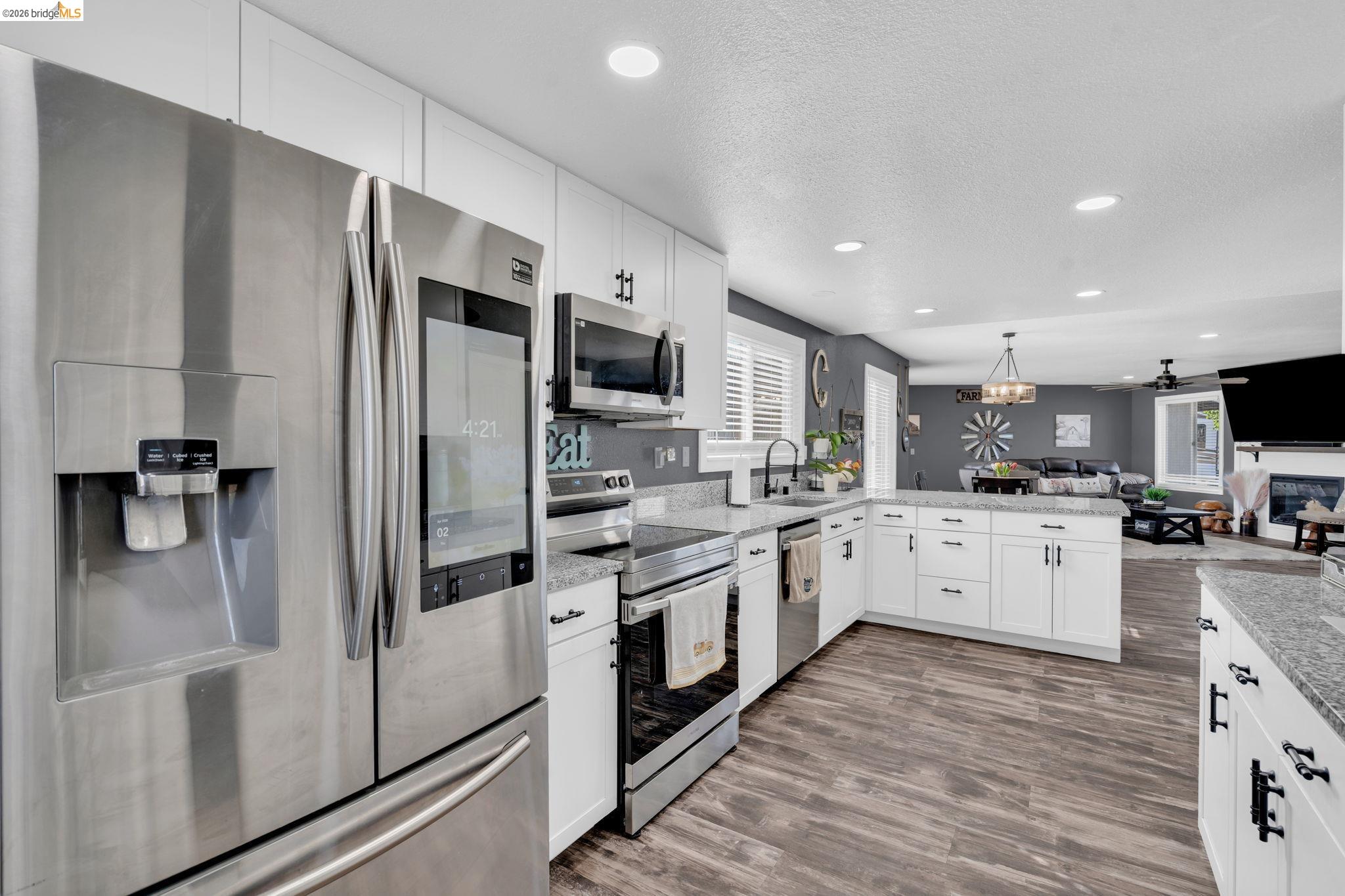 59 Old Stagecoach Road Brentwood, CA 94513 - Photo 21 of 70 Modern kitchen featuring stainless steel appliances, white cabinetry, granite countertops, wood-finish flooring, and recessed lighting