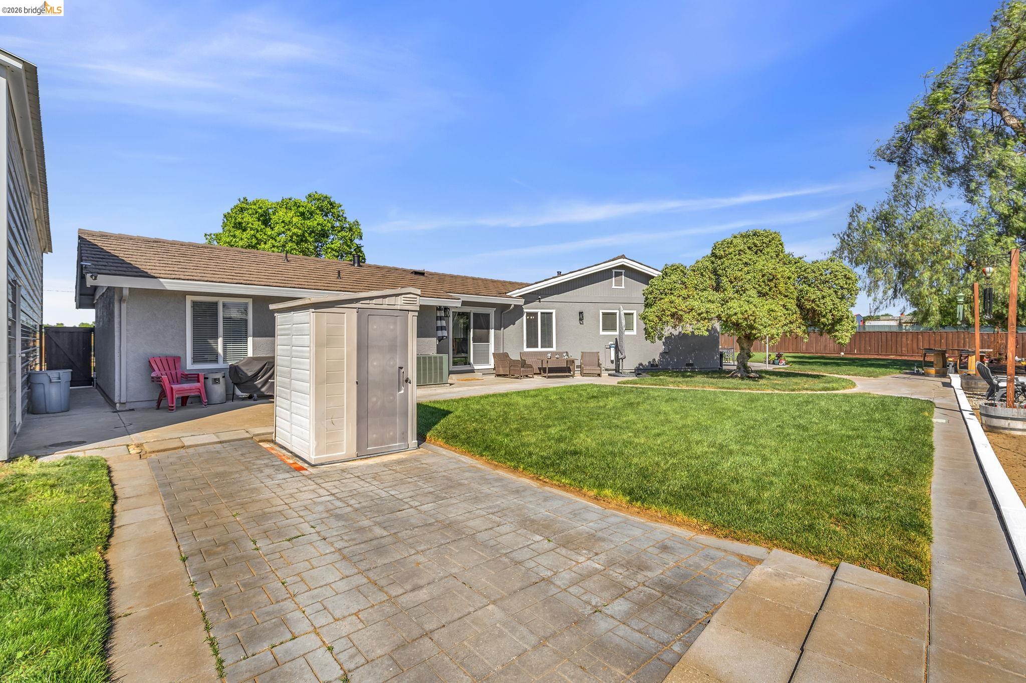 59 Old Stagecoach Road Brentwood, CA 94513 - Photo 51 of 70 Expansive outdoor space featuring a large manicured lawn, paver patio, mature trees, and a storage shed