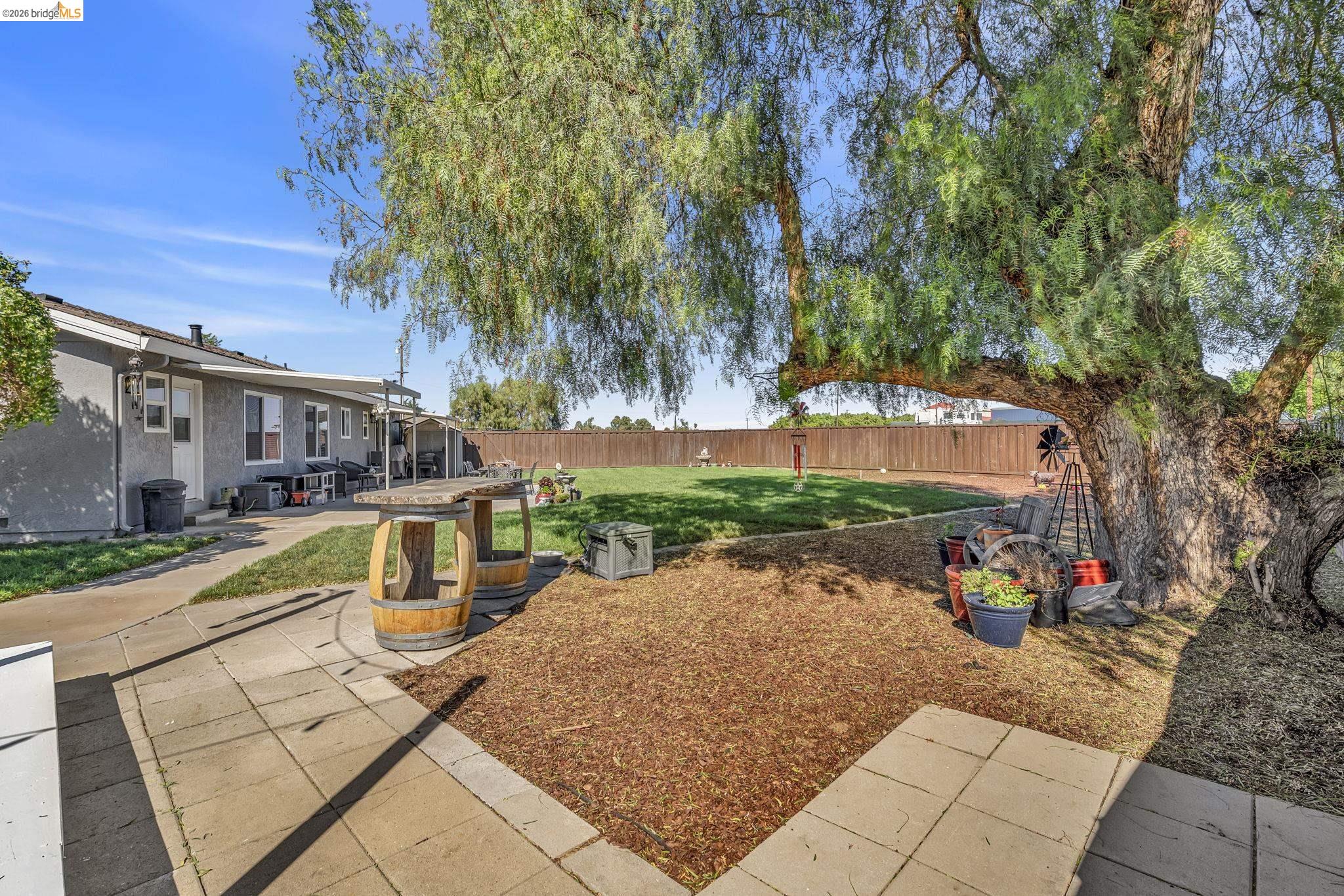 59 Old Stagecoach Road Brentwood, CA 94513 - Photo 58 of 70 Expansive backyard featuring a large mature tree, a paved patio area, and a grassy lawn