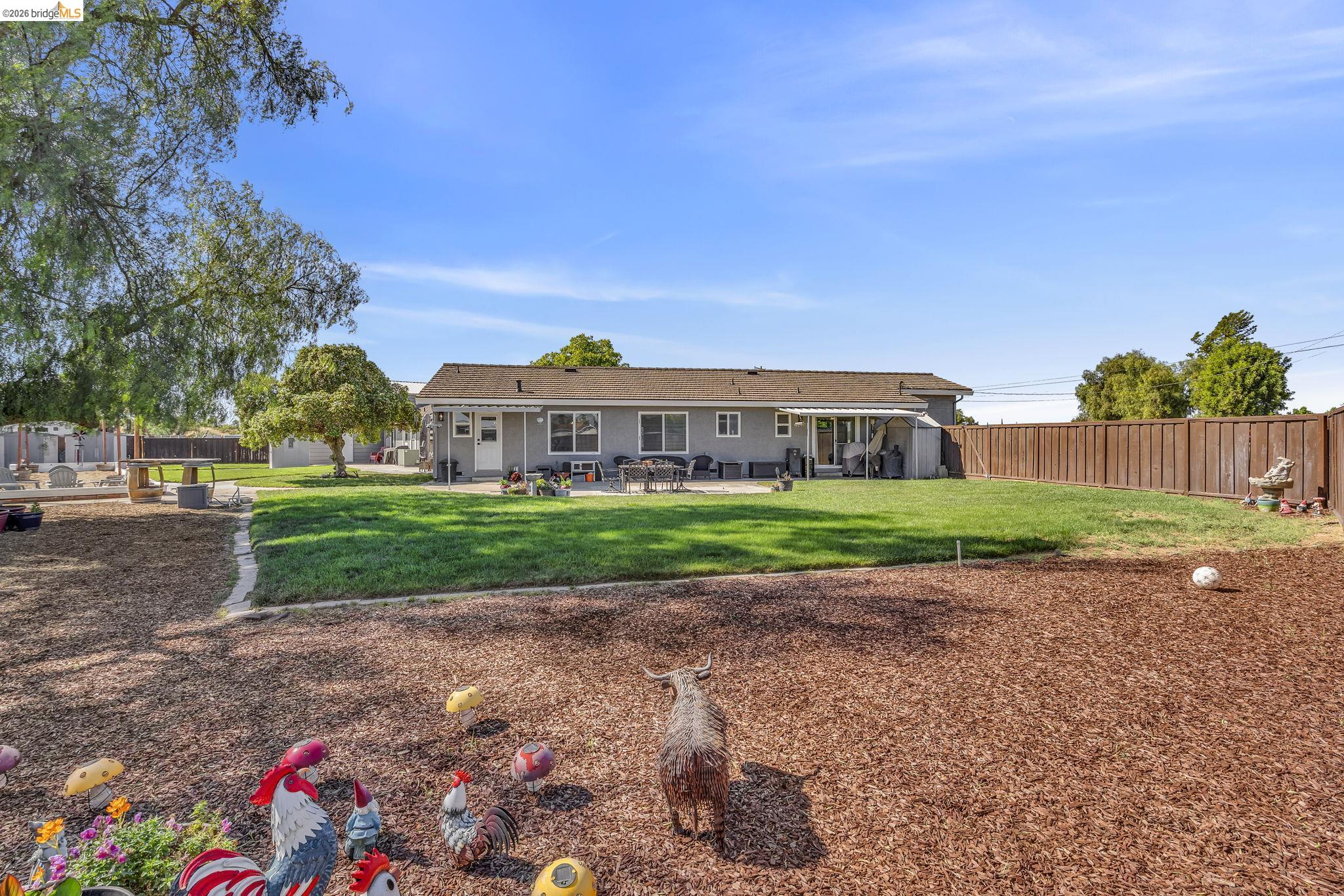 59 Old Stagecoach Road Brentwood, CA 94513 - Photo 59 of 70 Expansive backyard featuring a manicured lawn, wood chip landscaping, a full privacy fence, and mature trees