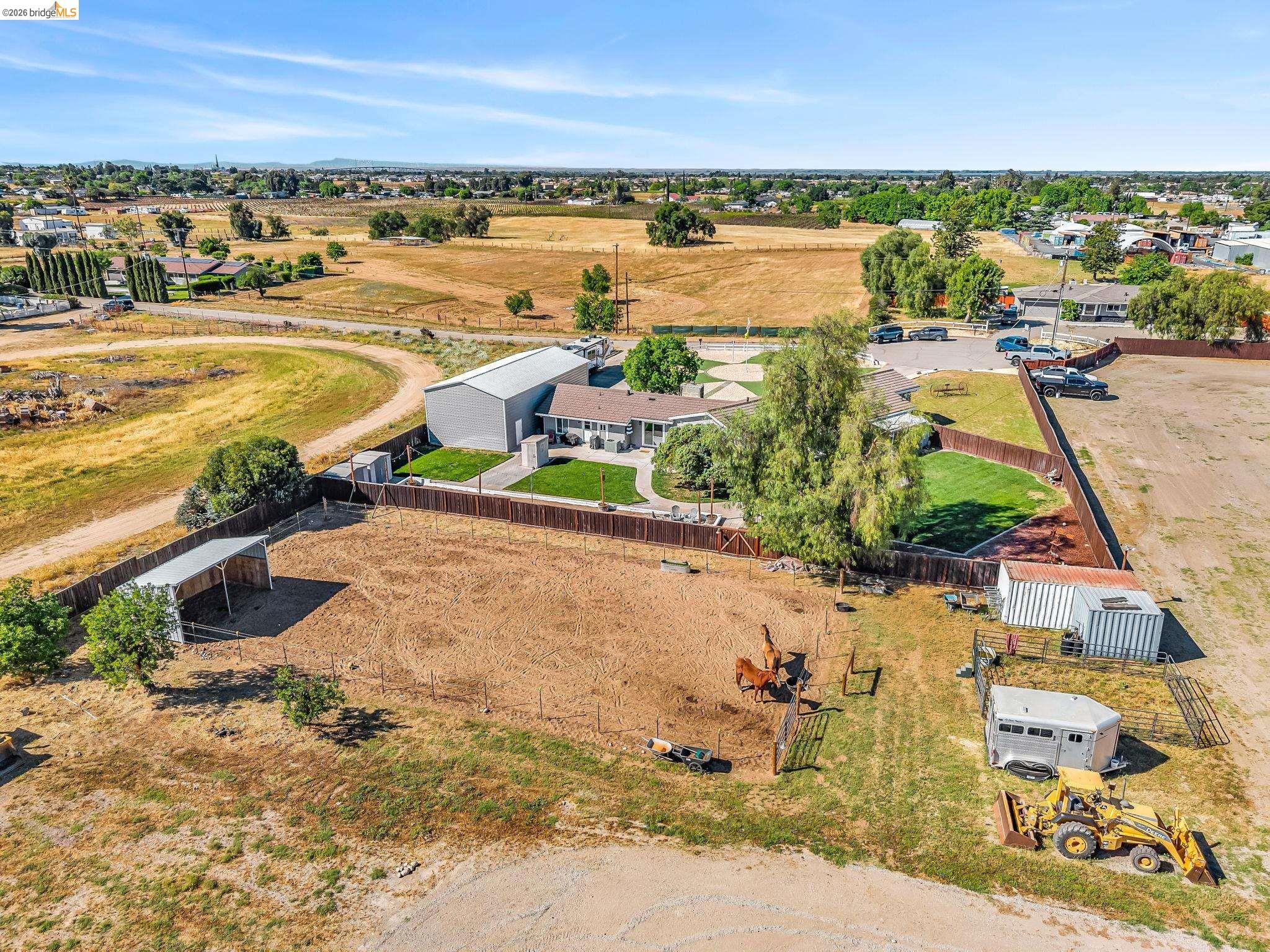 59 Old Stagecoach Road Brentwood, CA 94513 - Photo 63 of 70 Expansive property featuring a large main residence, a substantial metal-sided outbuilding, a fenced backyard with mature trees, and additional open land with a covered structure
