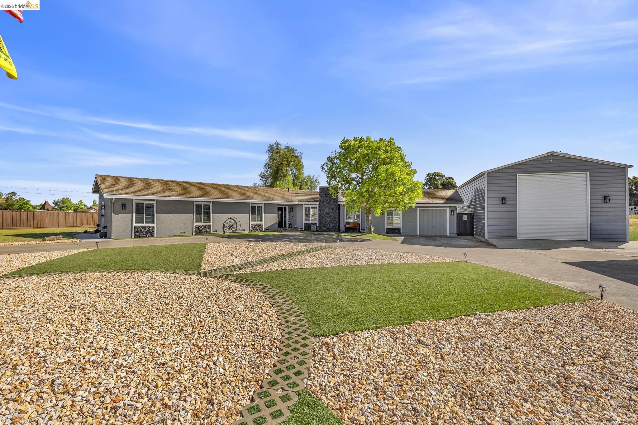 59 Old Stagecoach Road Brentwood, CA 94513 - Photo 10 of 70 Ranch-style residence featuring a gray exterior and a large detached metal garage with a roll-up door