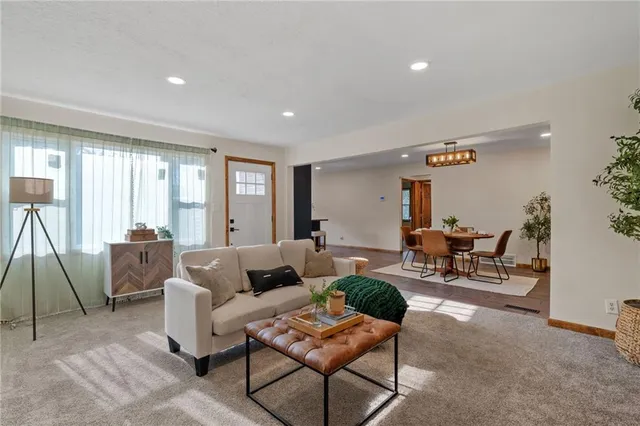 a living room with furniture and a dining table with wooden floor