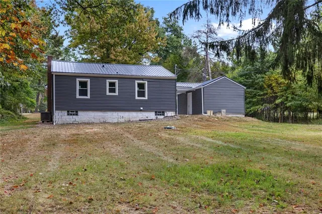 a view of a yard in front of a house with large tree