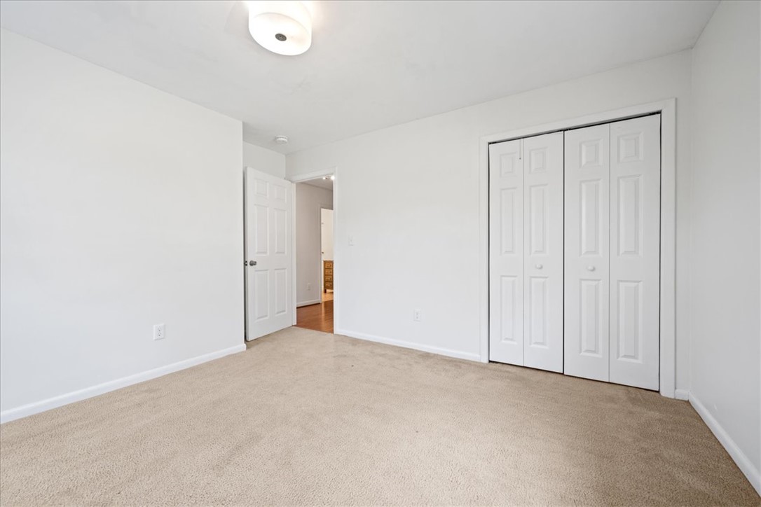 16 State Rd S-23-429 Greenville, SC 29609 - Photo 19 of 34 Plush neutral carpeting and white paneled closet doors define this cozy bedroom.