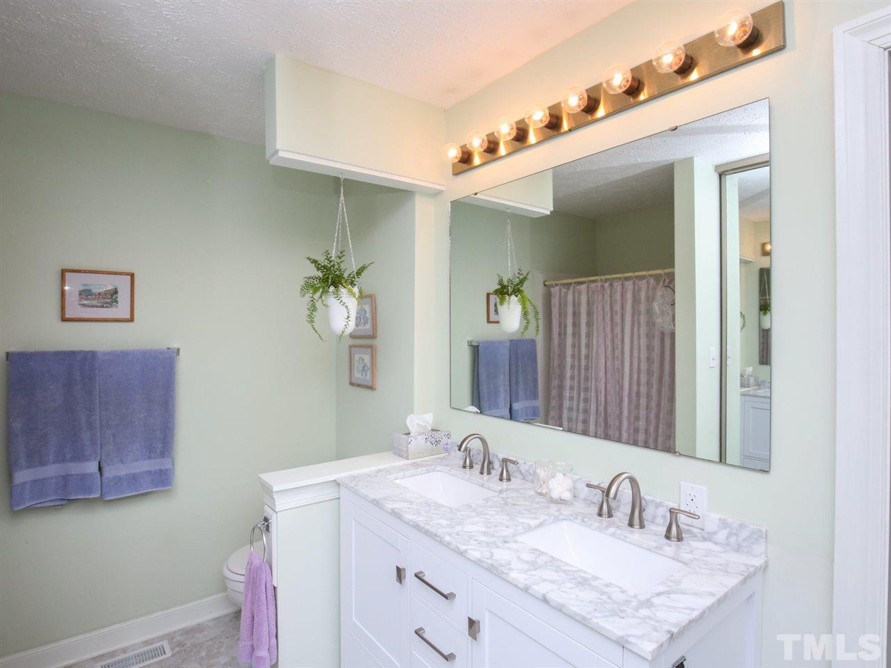 110 Trinity Woods Drive Raleigh, NC 27607 - Photo 14 of 30 a bathroom with a granite countertop sink and a mirror