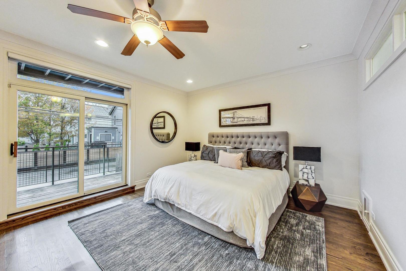 2848 North Sheffield Avenue, Unit 1N Chicago, IL 60657 - Photo 18 of 40 a bedroom with a large bed and a chandelier