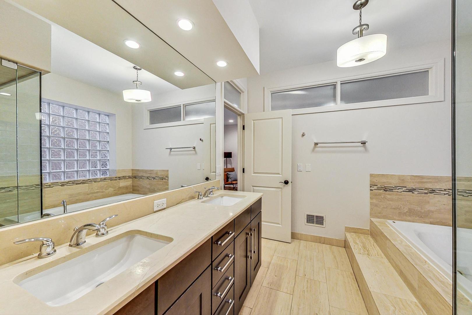 2848 North Sheffield Avenue, Unit 1N Chicago, IL 60657 - Photo 24 of 40 a spacious bathroom with a tub sink and mirror