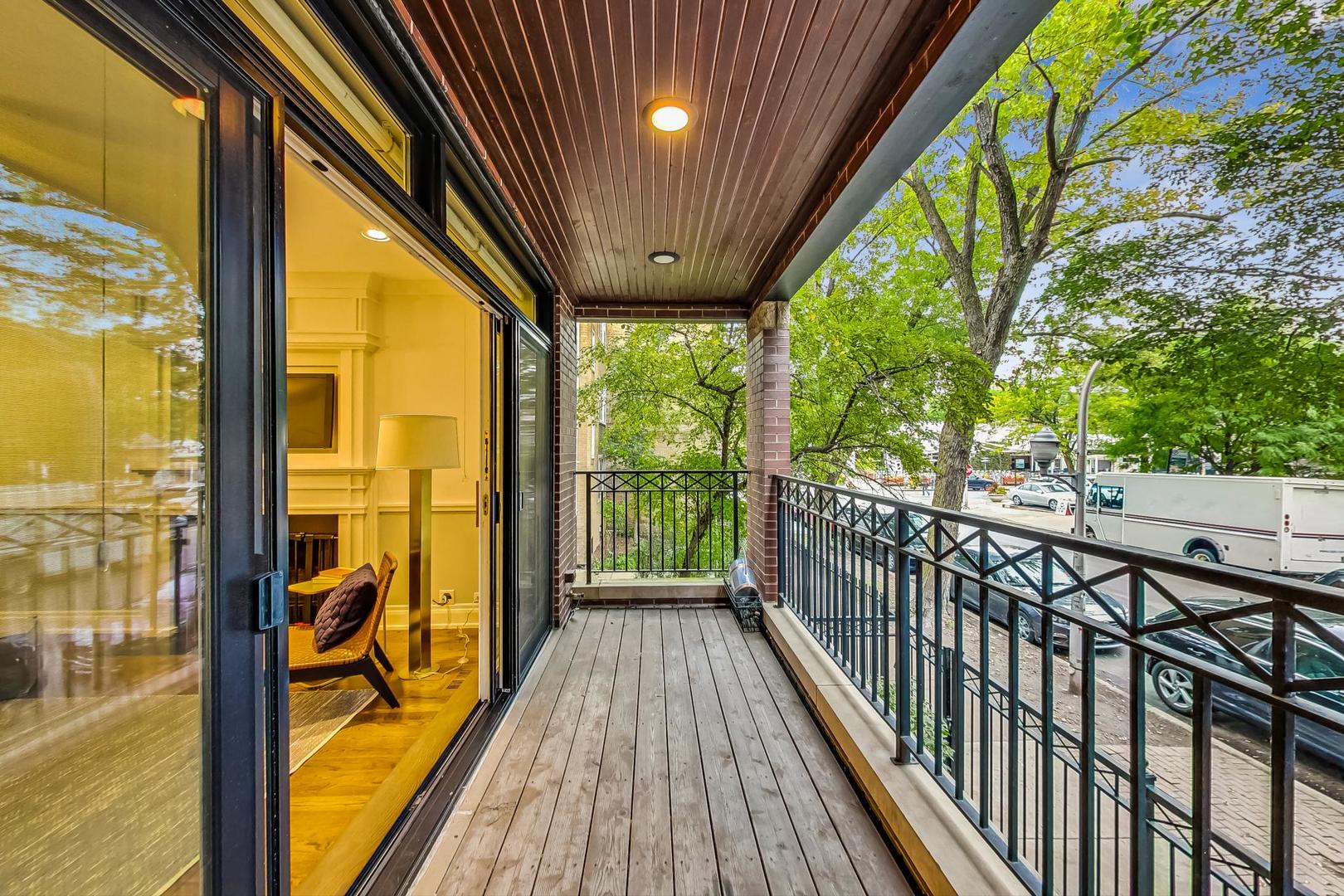 2848 North Sheffield Avenue, Unit 1N Chicago, IL 60657 - Photo 8 of 40 a view of balcony with floor to ceiling window wooden floor and outdoor seating