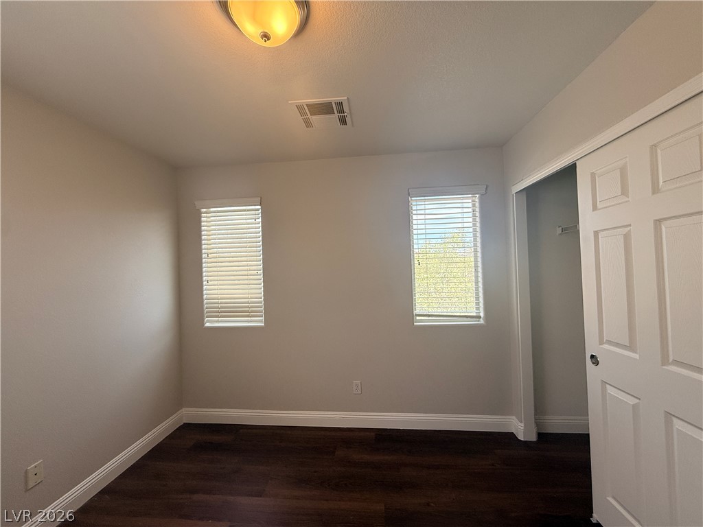 11953 Fairfax Ridge Street Las Vegas, NV 89183 - Photo 21 of 32 Rich hardwood-style flooring extends across this naturally illuminated, versatile bedroom space.