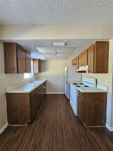 a large kitchen with stainless steel appliances granite countertop a lot of cabinets and wooden floor