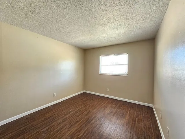 a view of a big room with wooden floor and windows in a room