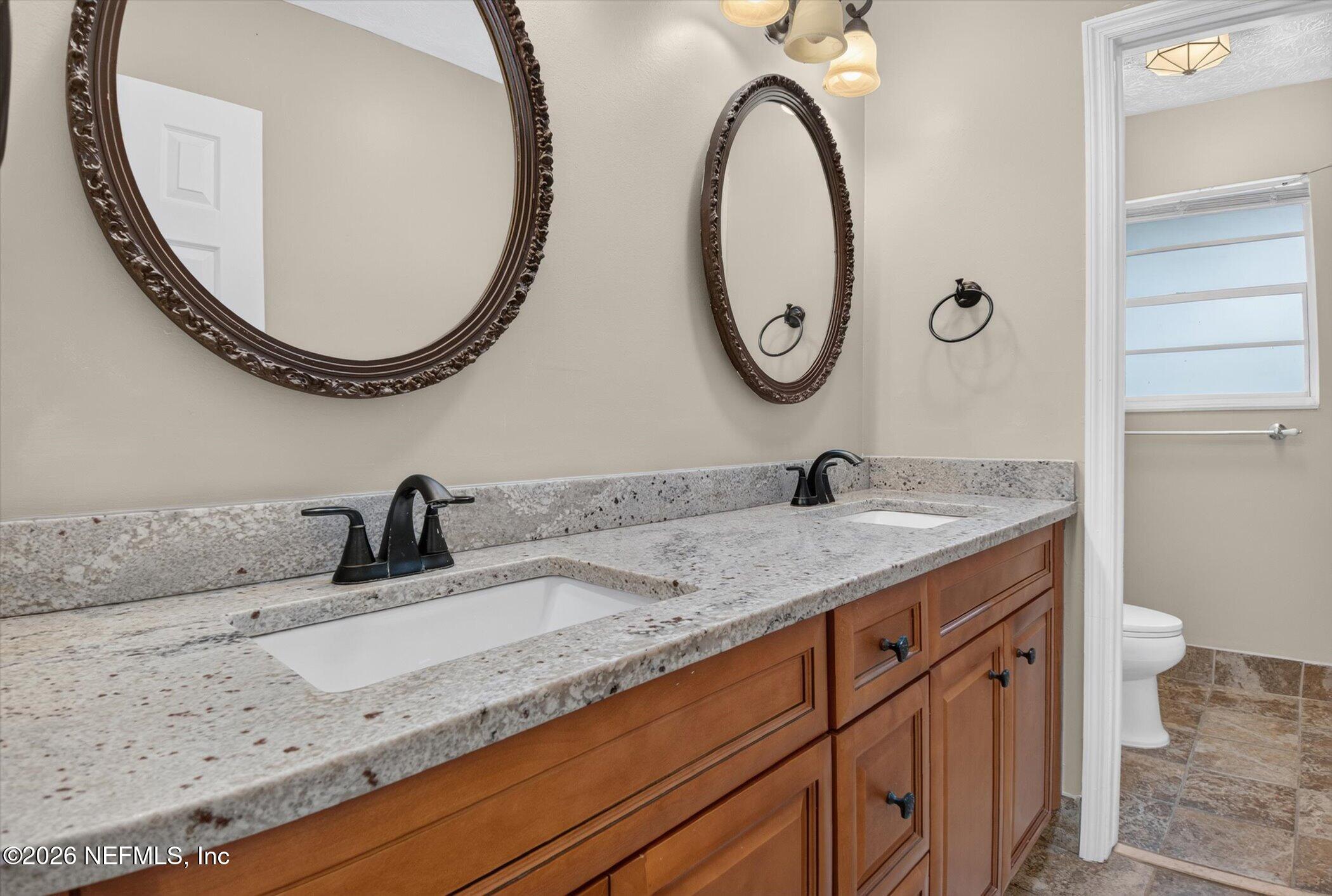 2705 Navajo Road Orange Park, FL 32073 - Photo 44 of 58 a bathroom with a granite countertop double vanity sink and a mirror
