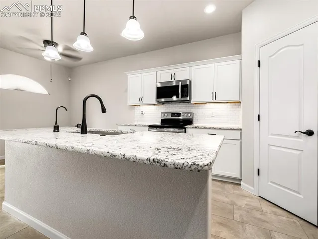 a kitchen with stainless steel appliances granite countertop a sink refrigerator and microwave